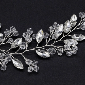 Detail of silver bridal hair vine with shimmering crystals and marquise stones on black