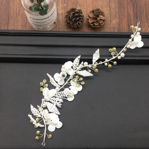 Detail view of handmade bridal hair vine with white fabric flowers and pearls on silver wire