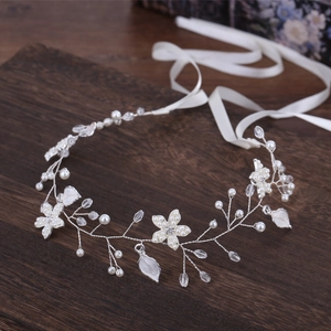 Détail d'un bandeau de mariée fait main avec perles blanches et fleurs en cristal
