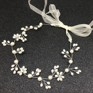 Vue détaillée de l'accessoire mariée avec perles blanches et fleurs en fil d'argent