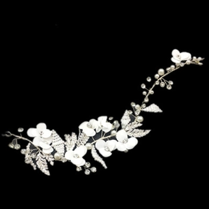 Close-up of bridal headband with white fabric petals, pearls and crystals on black background