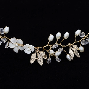 Detailed macro view of handmade bridal headband with gold leaves, pearls and crystals