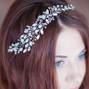 Detailed view of a silver crystal bridal hair vine accessory on curly red hair