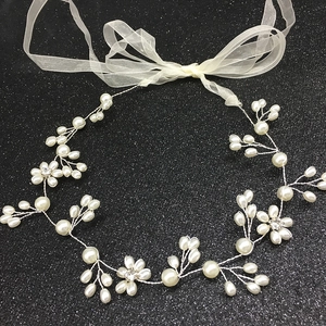 Détail de bandeau de mariée avec perles, strass et ruban en organza blanc élégant