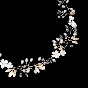 Detail of bridal hair vine with gold alloy leaves, white flowers and crystals
