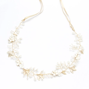 Detail of bridal headband with gold leaves, white flowers, pearls and crystal beads