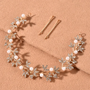 Détail d'une vigne de cheveux de mariée dorée avec des feuilles, perles et strass brillants