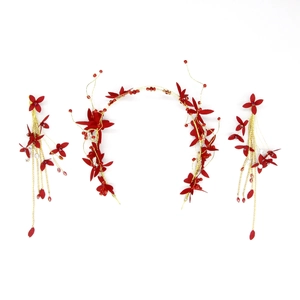 Détail du serre-tête à fleurs rouges et boucles d'oreilles à longs pompons de mariée
