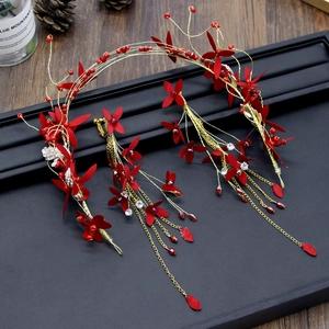 Détail du serre-tête floral de mariée rouge et des boucles d'oreilles sur support noir