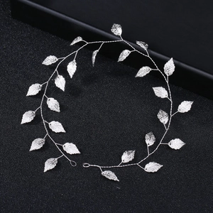 Détail d'un accessoire de cheveux de mariée en argent avec feuilles sur fond noir texturé