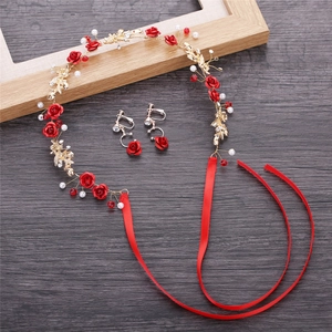 Dettaglio del set da sposa con rose rosse, filo dorato e perle per matrimoni