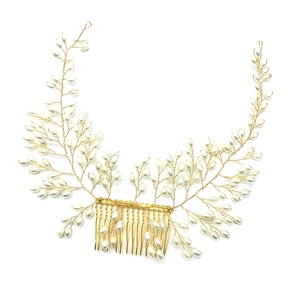 Détail d'un peigne de mariée doré avec perles blanches élégantes en motif de liane