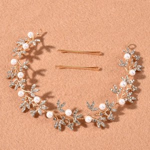 Détail d'une vigne de cheveux de mariée dorée avec perles et strass sur fond texturé