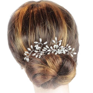 Détail d'une épingle à cheveux de mariée avec perles et branches de fil d'argent torsadé