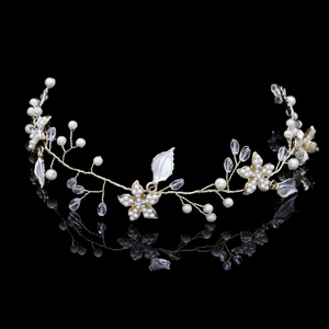 Détail d'un accessoire cheveux de mariée doré avec perles et cristaux scintillants