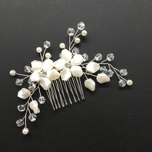 Macro shot of white resin flowers, pearls and crystal beads on a bridal hair comb