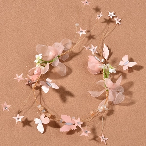 Dettaglio della fascia da sposa rosa con farfalle e fiori su uno sfondo strutturato