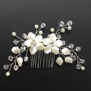 Detailed macro of white pearl bridal hair comb with silver wire and crystals