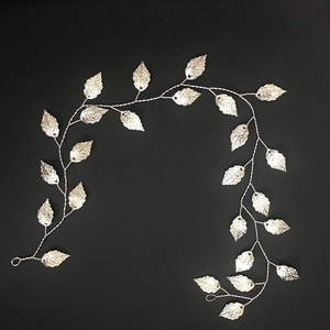 Détail d'une vigne de cheveux argentée pour mariée avec feuilles en métal ciselées