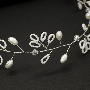 Close-up of handmade bridal hair vine with white pearls and crystals on silver wire