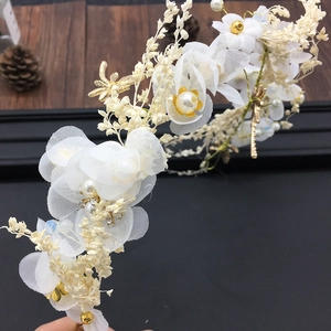 Détail du serre-tête de mariée fait main avec fleurs en gaze crème, perles et libellules