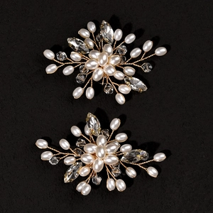 Détail de clips de chaussures de mariée faits main avec perles blanches et cristaux dorés