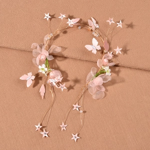 Dettaglio di fascia floreale con farfalla in tessuto rosa, filo dorato e cristalli
