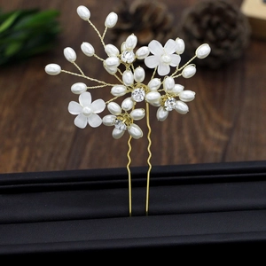 Detail of bridal hair pin with pearls and crystals on a gold U-shaped metal base