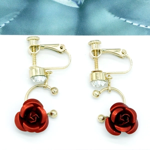 Vista macro dettagliata degli orecchini da sposa con rose rosse e cristalli lucidi