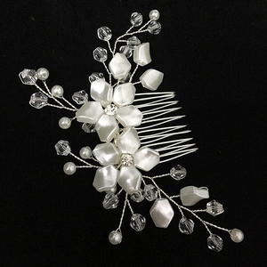 Detail of handcrafted bridal hair comb with white pearls and crystal flower accents