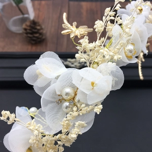 Détail d'accessoire cheveux mariage avec fleurs en tulle blanc, perles et libellule dorée