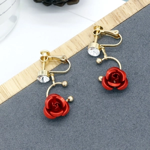 Vista dettagliata degli orecchini a clip con rosa rossa, filo dorato e zircone bianco