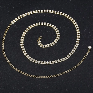 Détail macro de la chaîne de corps dorée à double rangée de strass avec fermoir