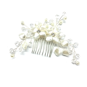Detailed view of bridal hair comb with ivory flowers and white pearls on silver metal wire