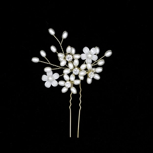 Close-up of handmade bridal hair pin with pearls, frosted flowers and sparkling crystals