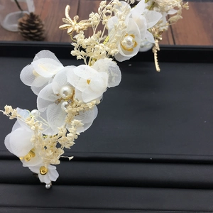 Détail de fleurs de mariée en résille avec libellules dorées et perles sur plateau