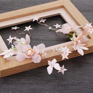 Dettaglio del tralcio per capelli da sposa con fiori rosa, stelle e strass dorati