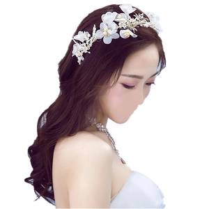 Détail de coiffe de mariée avec fleurs en soie blanches et perles et un collier argenté