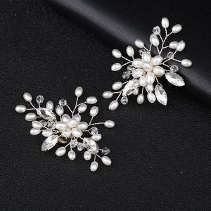 Détail de clips à chaussures de mariée faits main avec perles et cristaux sur fond noir