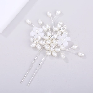 Detailed macro view of handmade bridal hair pin with pearls and rhinestone flower petal decor