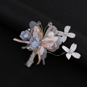 Close-up of handmade bridal flower hairpiece with blue chiffon petals and pearls