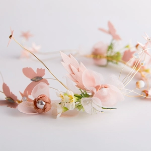 Dettaglio della fascia da sposa fatta a mano con fiori rosa e perle bianche