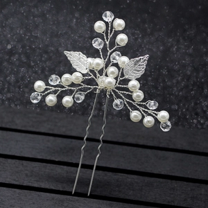 Macro de l'épingle à cheveux de mariée argentée avec perles et feuilles sur bois