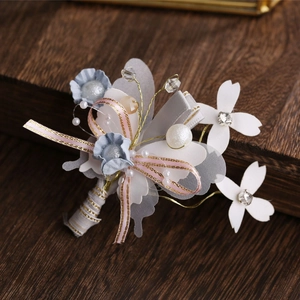 Macro shot of handmade blue and white fabric flowers with pearls and crystal beads