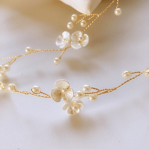 Macro view of bridal hair vine with handmade shell flowers and delicate white pearls