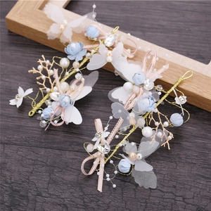Detail of blue silk flowers and tulle butterfly hair clips with pearls and rhinestones