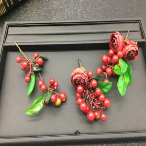 Detail of handmade bridal hair accessory with red silk roses and berries for wedding attire