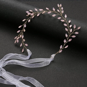 Detail of pink crystal bridal hair vine with golden wire leaves and organza ribbon