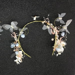 Detail of handmade bridal headband with gold wires, fabric butterflies and pastel floral accents