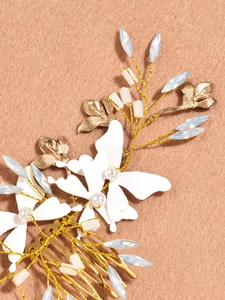 Détail du peigne à cheveux de mariée fait main avec fleurs d'or et pierres bleues